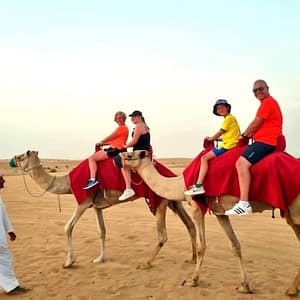 Camel Ride Safari in Red Dunes at Burj Khalifa Tower, Dubai, United Arab Emirates Camel Ride Safari in Red Dunes at Burj Khalifa Tower